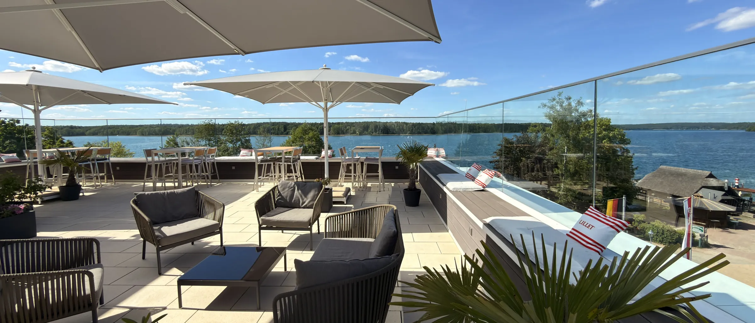 Dachterrasse des Fontane Hotels im Sommer: Sonnenschirme, Lounge und Blick über den Werbellinsee