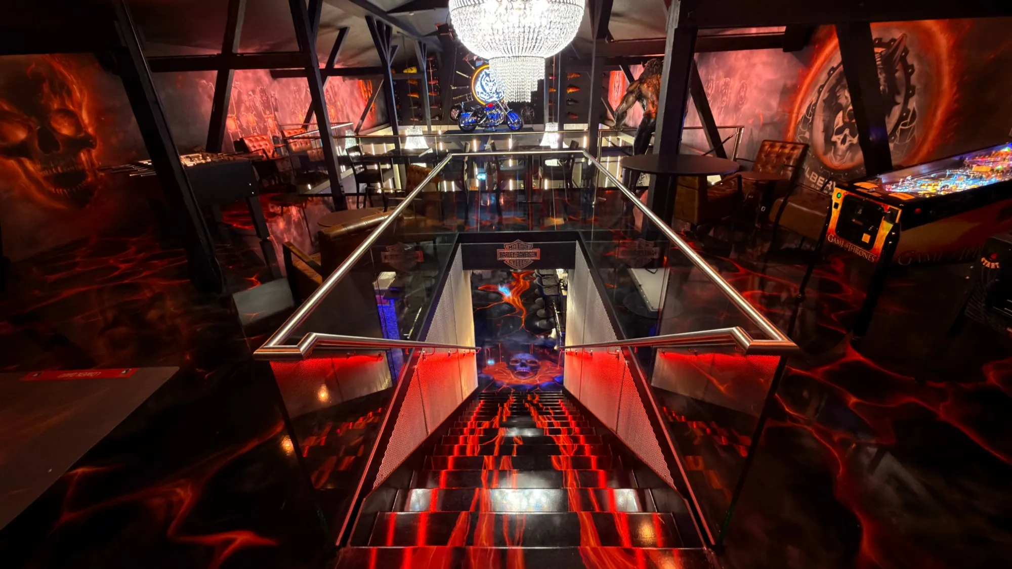 Barn of the Silberwolf Biker Bar: view down the staircase over the lava floor, chandelier, motorcycle and pinball machine under the beams