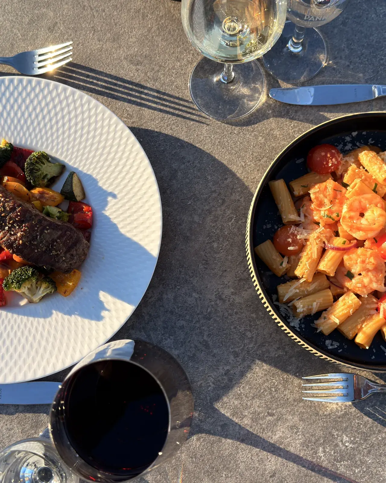 Two plates of regional cooking and a glass of red wine on the Theodors terrace
