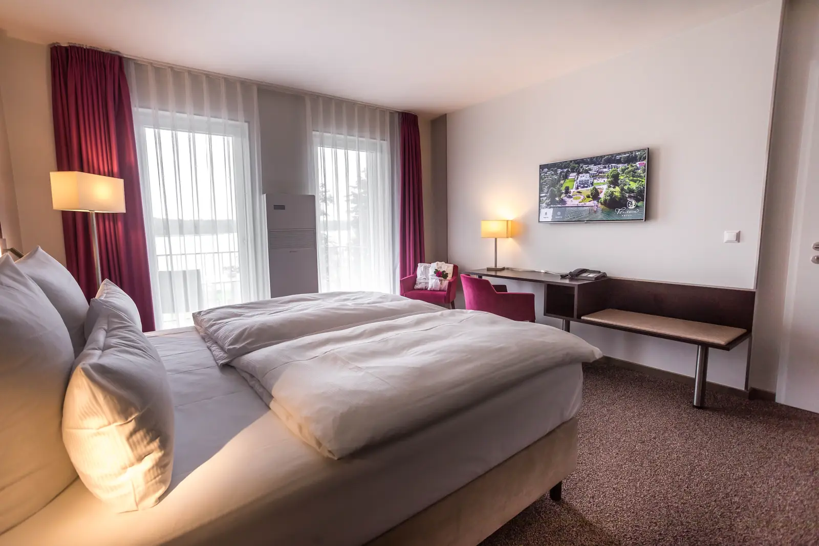 Doppelzimmer mit Balkon, Doppelbett und Schreibtisch am Fenster